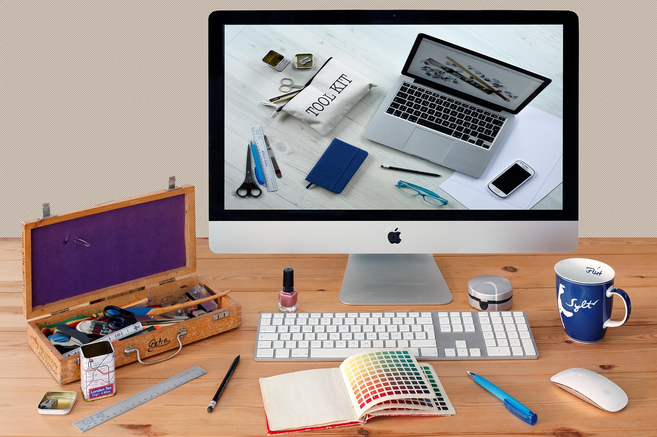 Designer's desk with an iMac, laptop and colour swatches