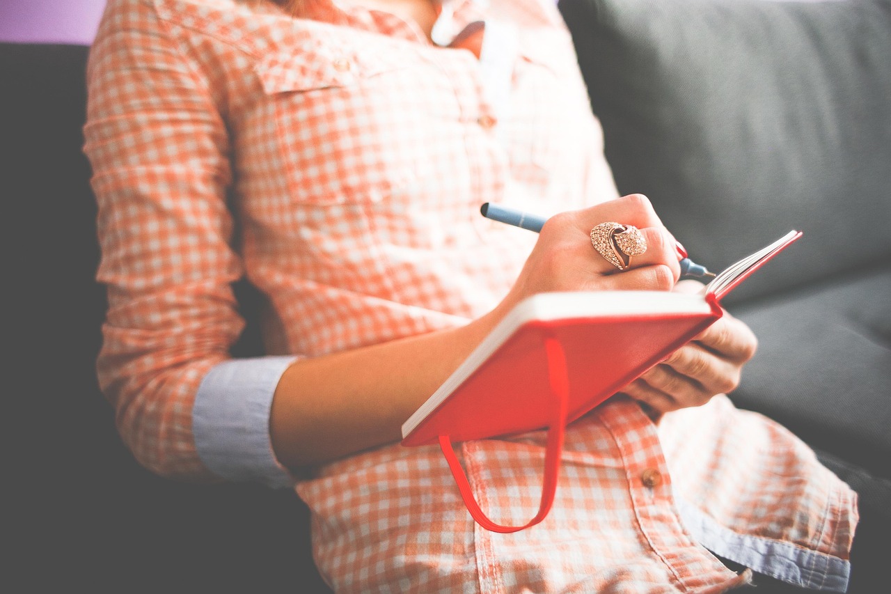 Writer taking notes in a notebook at her desk