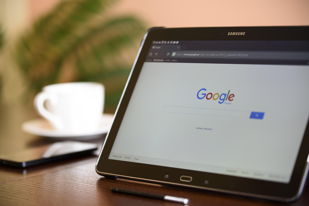 Tablet showing a search engine results page next to a notebook
